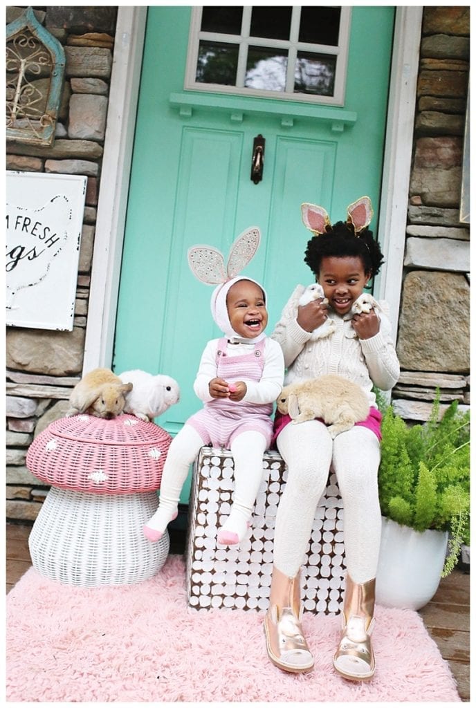 Two girls outside holding rabbits