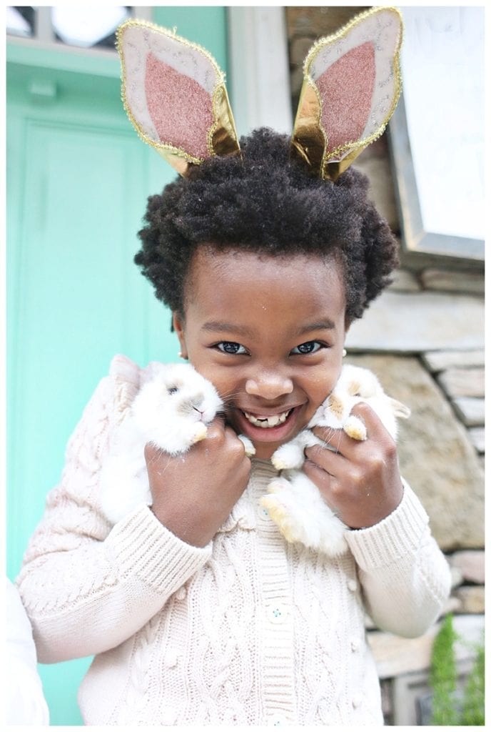Young girl wearing rabbit ears holding rabbit