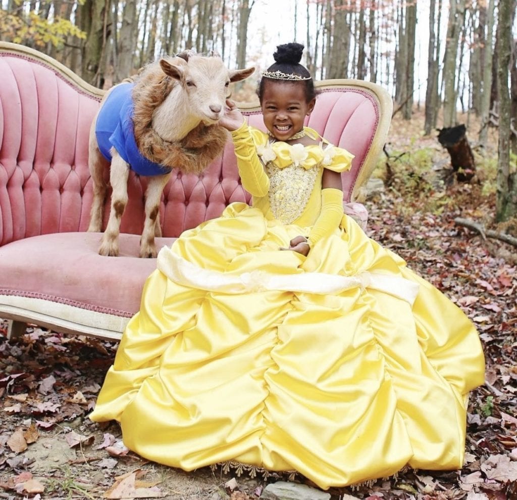 young girl in yellow belle dress with goat